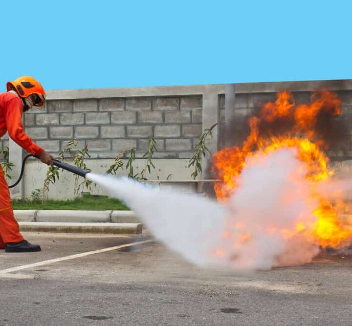 addetto con estintore che spegne un incendio per dimostrazione